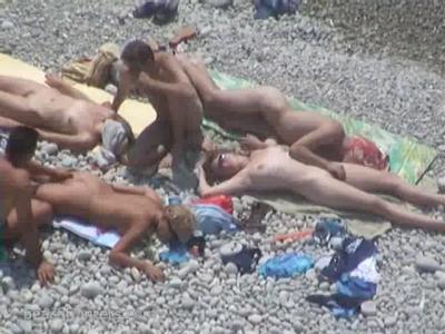 Жаркое лето.Пляж для нудистов.Молодые люди собрались позагорать на солнце.Оператор скрытой камерой снимает их расслабленные и обнаженные тела.